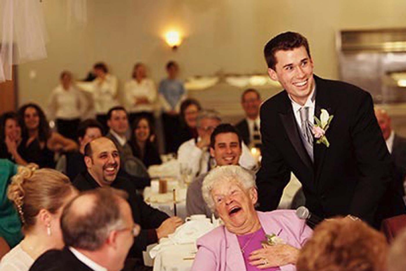 The groom laughing with a guest during the reception game show